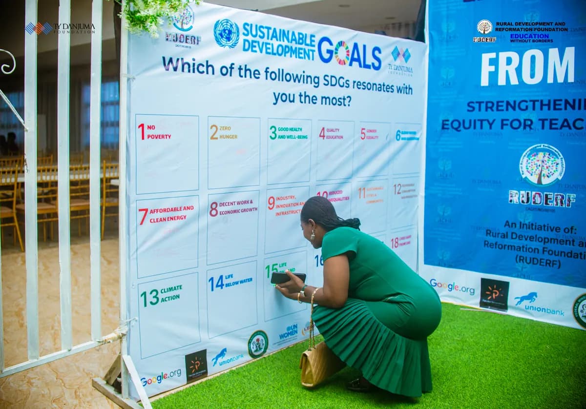 A woman signing on a sustainable development goals banner, a program organized by ruderf